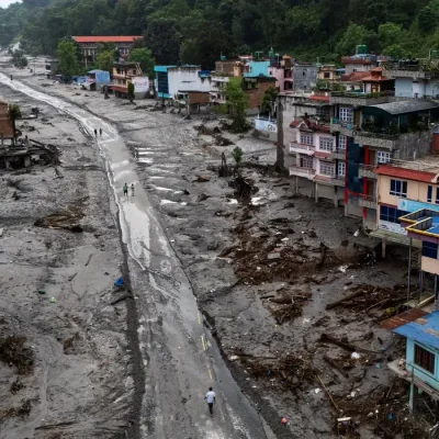 Imagem captada por um drone mostra pessoas caminhando por uma estrada e casas cobertas de lama após enchentes e deslizamentos de terra fatais, em Devighat, distrito de Nuwakot, no Nepal
30 de agosto de 2026
REUTERS/Athit Perawongmetha