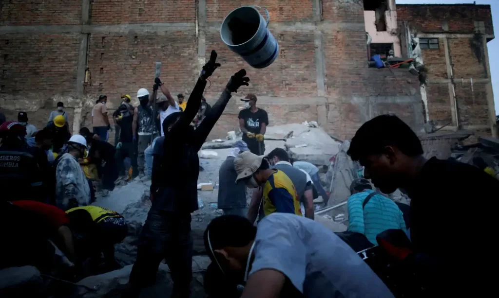 Pessoas recolhem escombros no local onde um prédio ruiu em Pereira, na Colômbia, após o terremoto de segunda-feira. August 11, 2026. REUTERS/Juan David Duque TPX IMAGES OF THE DAY