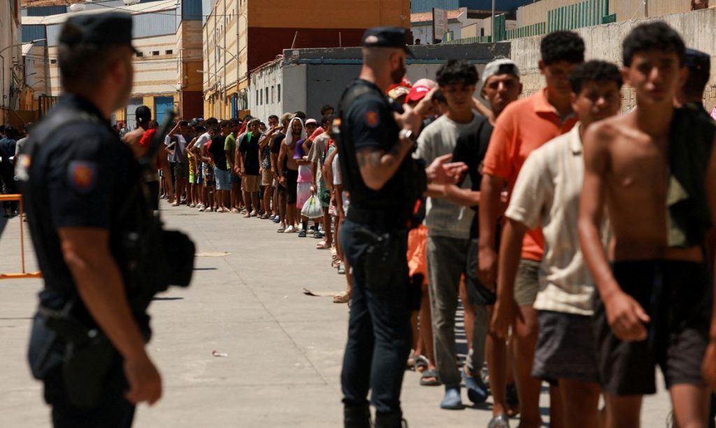 Imigrantes fazem fila para receber alimentos básicos da ONG local Media Luna Blanca em uma área industrial onde estão dormindo, em Ceuta, Espanha
6 de agosto de 2026 REUTERS/Violeta Santos Moura/Proibida Reprodução