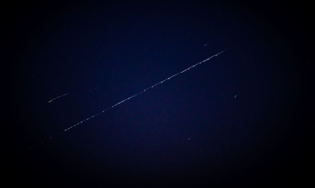 Constelação de satélites Starlink no céu noturno.