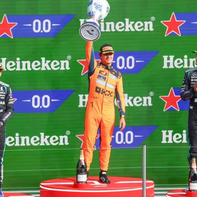 Formula One F1 - Dutch Grand Prix - Circuit Zandvoort, Zandvoort, Netherlands - August 23, 2026
McLaren's Lando Norris celebrates on the podium with the trophy after winning the Dutch Grand Prix alongside second placed Mercedes' Andrea Kimi Antonelli and third placed Mercedes' George Russell REUTERS/Jakub Porzycki     TPX IMAGES OF THE DAY