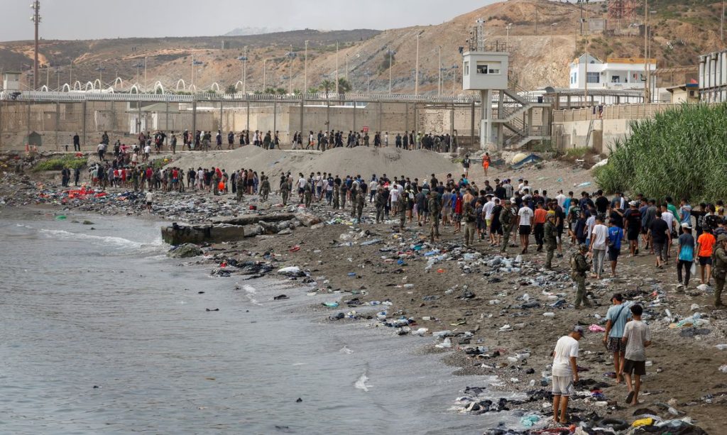 People walk towards the border with Morocco leaving Spain, amid mass crossings of migrants on foot and by sea from Morocco into Spanish territory, in Ceuta, Spain, July 31, 2026. REUTERS/Jon Nazca TPX IMAGES OF THE DAY
