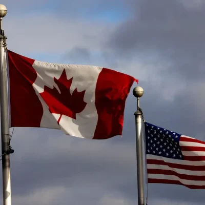 Flags wave in the wind near the Detroit River which seperates Windsor, Ontario, Canada, and Detroit, Michigan, U.S., in Windsor, Ontario, Canada February 4, 2025. REUTERS/Carlos Osorio
