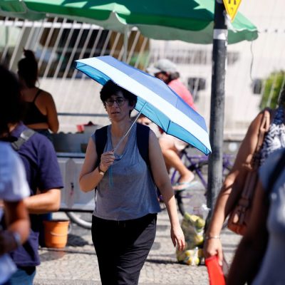 Rio de Janeiro (RJ), 17/02/2024 -Transeuntes se protegem do forte calor nas ruas do centro da cidade. Cidade do Rio de Janeiro atinge nível 4 de calor. Marco é caracterizado por temperaturas que podem chegar a 44ºC  Foto: Tânia Rêgo/Agência Brasil