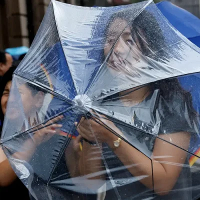Uma pessoa segura um guarda-chuva para se proteger dos ventos fortes antes da chegada do tufão Dolphin em Xangai, na China, em 9 de agosto de 2026. REUTERS/Go Nakamura