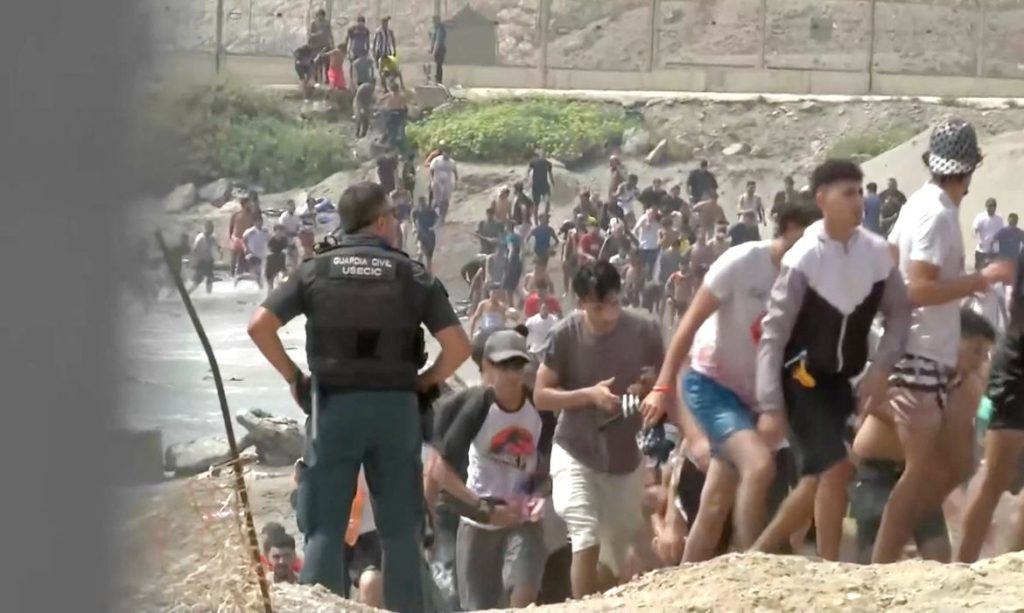 Migrantes caminham ao lado de um membro da Guarda Civil pós atravessarem a nado a fronteira de Ceuta, Espanha, vindos do lado marroquino
30 de julho de 2026
captura de tela obtida de um vídeo
Atlas/via Reuters TV/Divulgação via REUTERS
