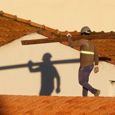 Operários reformam telhado de imóvel em obras no Centro do Rio.