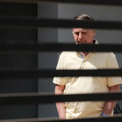 Brazil's former President Jair Bolsonaro stands at his home while under house arrest, amid the final phase of his trial, accused of plotting a coup after his electoral defeat, in Brasilia, Brazil, September 3, 2025. REUTERS/Diego Herculano REFILE - CORRECTING DATE FROM