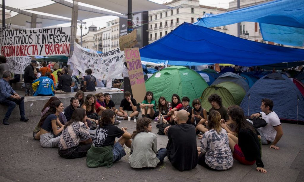 Protesters seated on the ground hold an assembly, surrounded by tents at Puerta del Sol in central Madrid, during a protest camp against the high cost of housing and rent in Spain. The protest arose following the eviction of Maricarmen, an 87-year-old woman, from her apartment in Madrid.