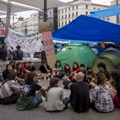 Protesters seated on the ground hold an assembly, surrounded by tents at Puerta del Sol in central Madrid, during a protest camp against the high cost of housing and rent in Spain. The protest arose following the eviction of Maricarmen, an 87-year-old woman, from her apartment in Madrid.