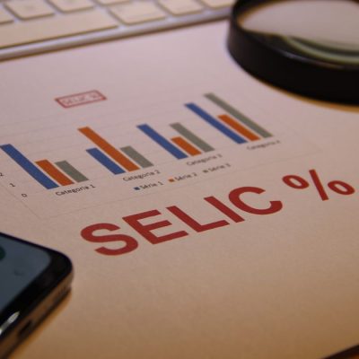 Taxa Selic - Gráfico representando evolução, lupa, teclado e calculadora. Foto: Luciano Luppa/ Adobe Stock